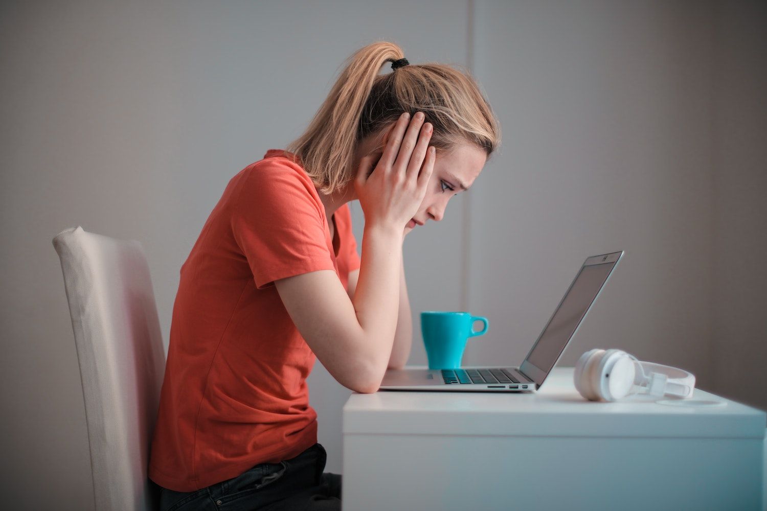 junge-frau-sitzt-nachdenkend-am-laptop-mrj